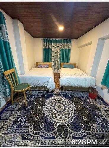 a room with two beds and a chair and a rug at Sungava homestay in Mirik