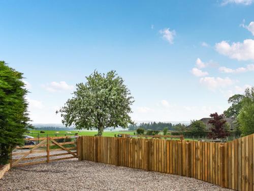 a wooden fence with a gate and a tree at The Garden Pod in Brechin