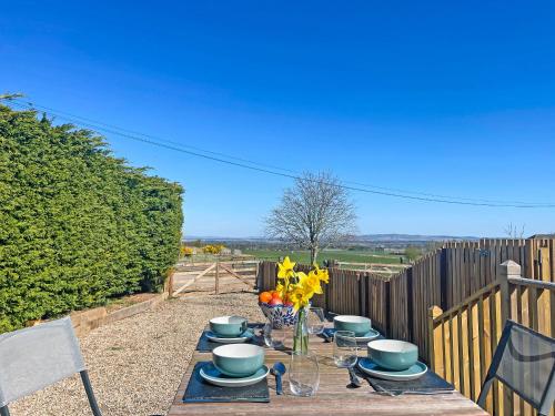 a wooden table with plates and flowers on it at The Garden Pod in Brechin