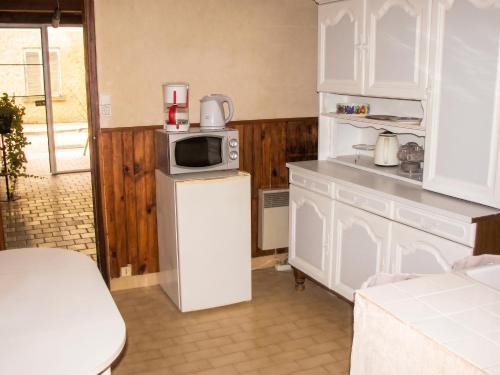 a kitchen with a microwave on top of a refrigerator at Studio confortable près de Beaumont-du-Périgord, 60 m², cheminée in Beaumont-du-Périgord