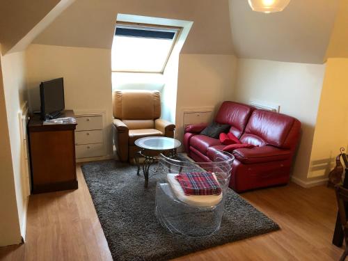 a living room with a red couch and a table at Appartement cosy à Sannois de 110 m² avec jardin clôturé in Sannois