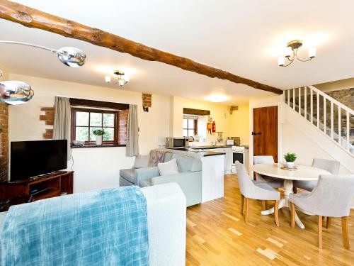 a kitchen and living room with a table and chairs at Ible Cottage - Qve in Hognaston