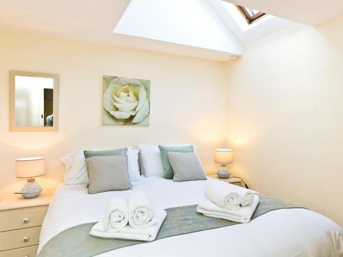 a bedroom with a bed with towels on it at Ible Cottage - Qve in Hognaston