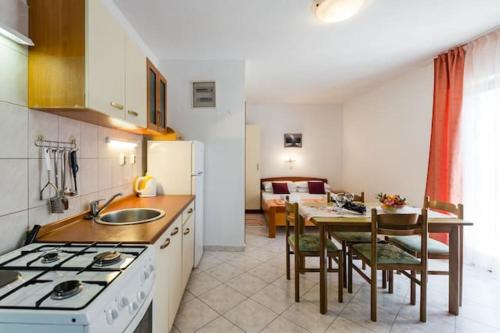 a kitchen with a stove and a table with chairs at Charming Studio in Zavala - 25 m² - Parking Included in Zavala