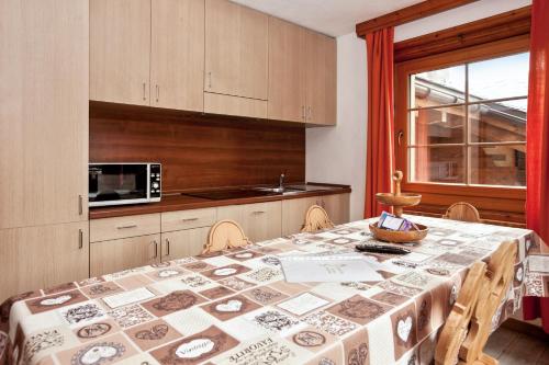 a kitchen with a table with a table cloth on it at Comfortable Apartment in Livigno with Balcony in Livigno