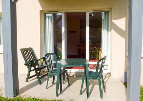 a green table and chairs on a patio at Appartement accueillant Saint-Lary-Soulan 45 m² Piscine partagée in Saint-Lary-Soulan