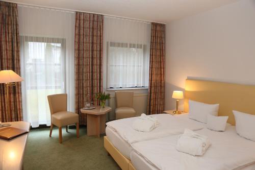 A bed or beds in a room at Lindenhotel Stralsund