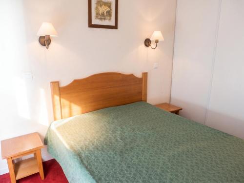 a bedroom with a bed with a green comforter at Appartement accueillant Saint-Lary-Soulan 45 m² Piscine partagée in Saint-Lary-Soulan