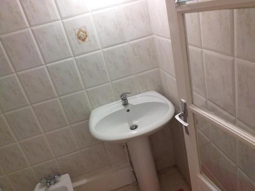 a white sink in a bathroom with a shower at Appartement charmant Morne-À-l'Eau in Morne-à-lʼEau