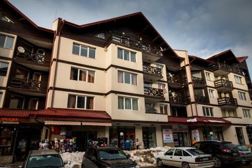 a large building with cars parked in front of it at Iglika 2 Ski Apartment in Borovets