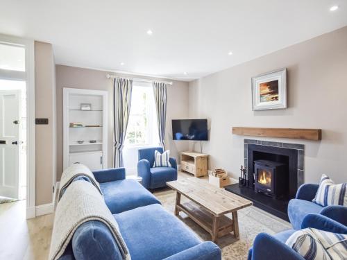 a living room with blue couches and a fireplace at Struan in Kilconquhar