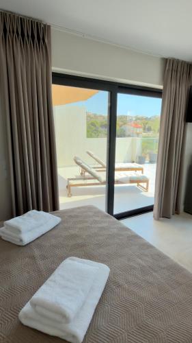 a bedroom with a bed with two white towels on it at CasaMare Lagonisi Athens Riviera Luxury modern villas apartment's in Lagonissi