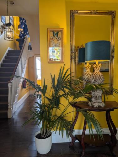a yellow hallway with a table and a plant at The Southbank Torquay by the sea in Torquay