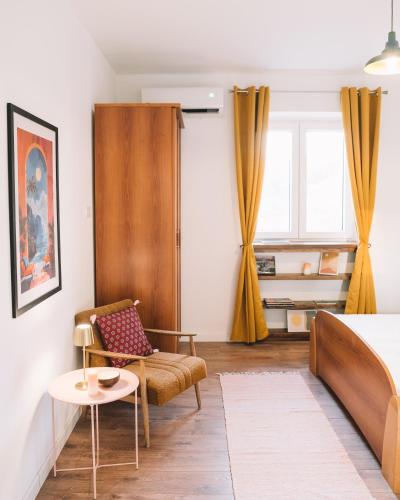 a bedroom with a bed and a chair and a table at Casa Hollaj in Vladimir