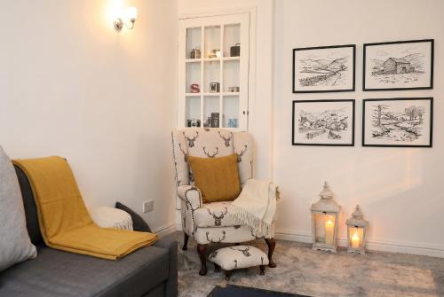 a living room with a chair and a couch at Willow Cottage in Pateley Bridge