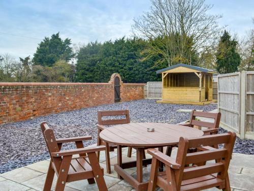 a wooden table and chairs in a backyard with a fence at George's Gaff - E4432 in Ingoldmells