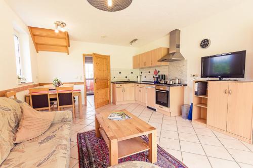 a living room with a couch and a table and a kitchen at Waldlust in Abtsgmünd