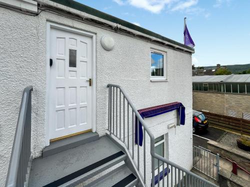 a stairway leading up to a white door at Heathergems Apartment in Pitlochry
