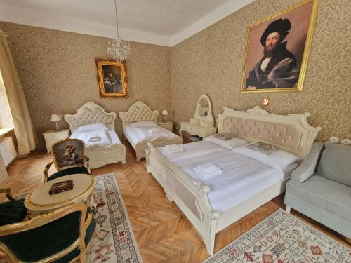 a bedroom with two beds and a couch at Apartmány Svätá Barborka in Banská Štiavnica