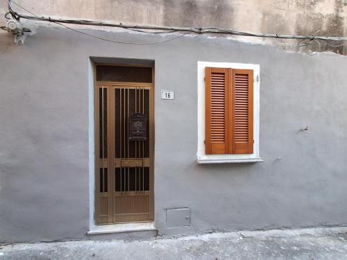 a white building with a door and a window at Casa relax Mele in Siniscola