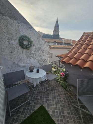 a patio with a table and chairs and a building at Villa Darche in Vrbnik