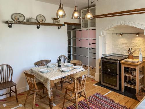 a dining room with a table and chairs and an oven at Enginemans Cottage in Bishop Auckland