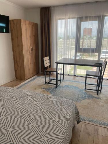 a bedroom with a bed and a table and chairs at Гостевой дом Бакай in Imeni Kirova