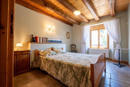 a bedroom with a bed and a window at Digitales en margeride in SAINT DENIS EN MARGERIDE