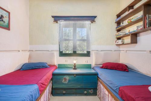 two beds sitting in a room with a window at Elia Cottage in Sitia