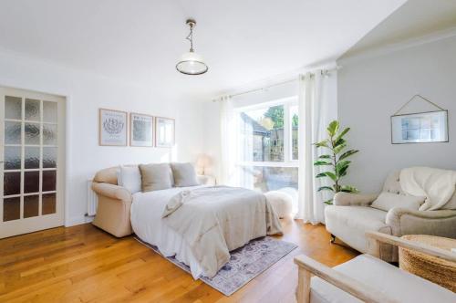 a white living room with a bed and a couch at Ascot House in Buxton