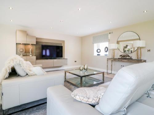 a living room with a white couch and a tv at 15 Chivits - Ukc8971 in Warkworth