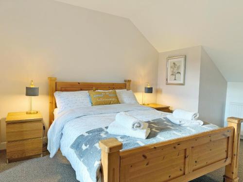 a bedroom with a large bed with towels on it at Leaderfoot Cottage in Selkirk