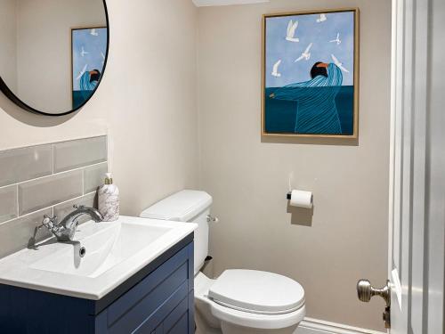 a bathroom with a toilet and a sink and a mirror at Stone's Throw in Richmond
