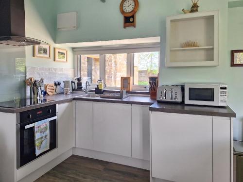 a kitchen with white cabinets and a microwave at The Studio At Westfield in Bellingham