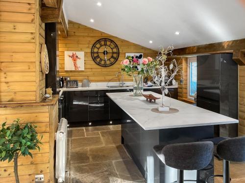 a kitchen with a counter and a clock on the wall at Eagle Lodge in Cowbridge