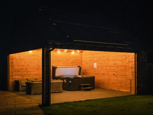 a screened in patio at night with a couch and a tv at 13 Shearling - Ukc8974 in Warkworth