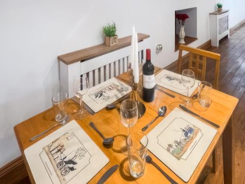 a wooden table with wine glasses and wine bottles at Stewards Granary - Uk48306 in Berwick-Upon-Tweed