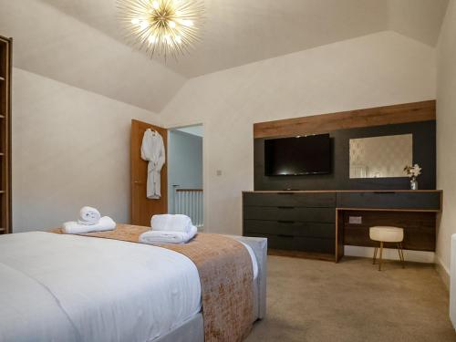 a bedroom with a bed and a tv on the wall at 12 Galloway - Ukc8975 in Warkworth