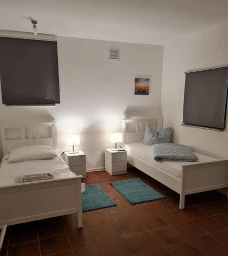 a bedroom with two beds and two lamps and a flat screen tv at Fewo-Am-alten-Bahnhof in Tangerhütte