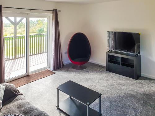 a living room with a couch and a tv and a table at Classroom One - Uk48650 in Lifton