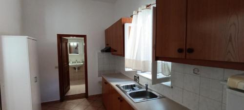 a small kitchen with a sink and a mirror at Siel Oneiro House in Ermoupoli