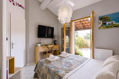 a bedroom with a bed and a tv and a window at Cap Anguilla, chambre d'hôtes in Carnoux