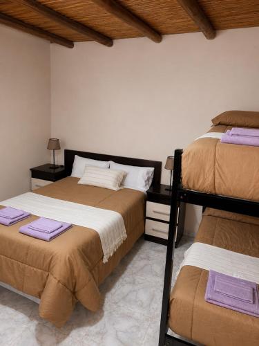 a bedroom with two bunk beds and purple towels at Talahuasto in Los Baldecitos
