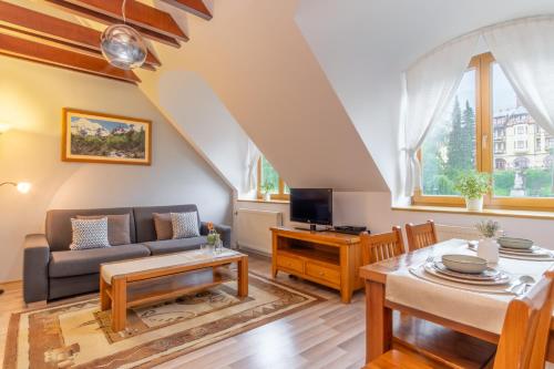 a living room with a couch and a table at Central Apartmany in Starý Smokovec
