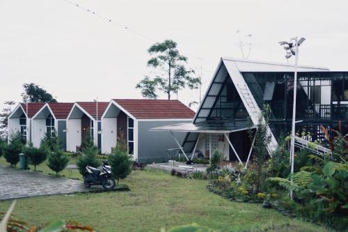 a house with a motorcycle parked in front of it at CYB Merbabu Resort & Cafe in Kembang