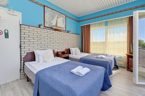 two beds in a room with blue walls at Päeva Villa in Haapsalu