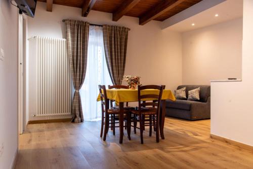 a dining room with a table and chairs and a couch at La Stella del Borgo in Castelmezzano