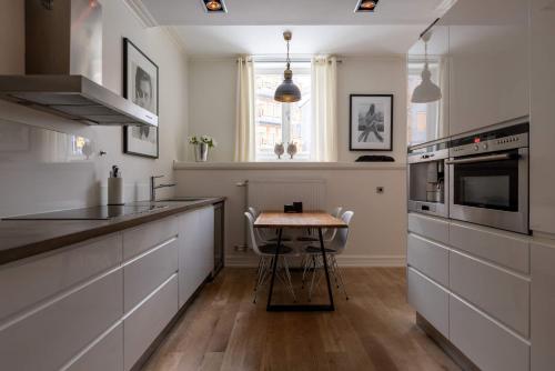 a kitchen with white cabinets and a wooden table at Central Stylish Retreat with Sauna in Åre