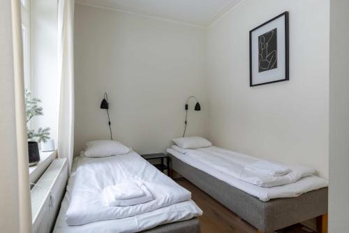 two beds in a room with white walls at Central Stylish Retreat with Sauna in Åre