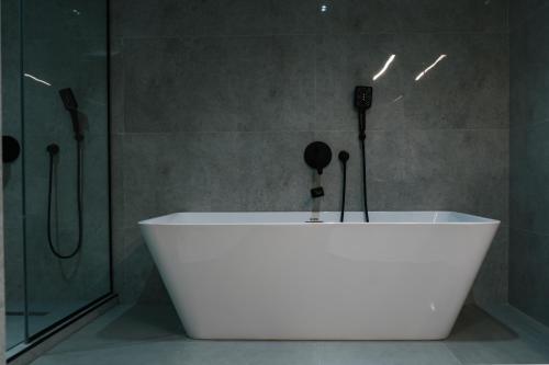 a white tub in a bathroom with a shower at Kohinur Plaza in Samarkand